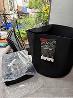 Unfolded Infinity Pot fabric planter and sealed package containing additional folded planters