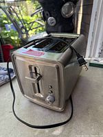 Front angled view showing stainless housing, slots, power cord