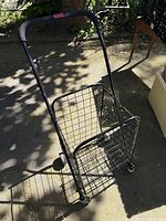 Open view of black folding wire shopping cart with four wheels and handle