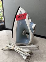 Front left view of steam iron showing housing, dial, cord