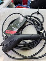 Full view of Jeep EV charging cable showing control box, vehicle connector, and household plug