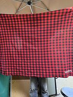 Full view of red and black check throw blanket held open