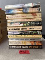 Stack of 11 paperback books showing spines for title identification