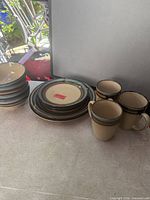 Stack of bowls, plates, and mugs showing color and quantity