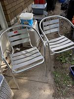 Pair of matching aluminum patio chairs side by side