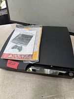 Top view of PS3 Slim console with Quick Start guide packaged on top