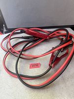 Coiled red and black booster cables showing clamps and insulation