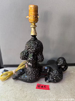 Front view of ceramic poodle lamp showing socket and cord