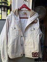 Full front view of off-white Sisley hooded jacket on hanger