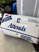 Front view of sealed Attends disposable briefs pack showing brand, size and 24-count information