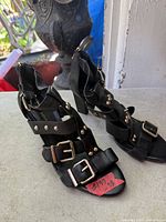 Side view of both sandals showing straps, buckles, studs and heels