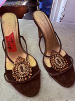 Top view of both sandals showing suede uppers, jeweled medallions, ALDO insoles
