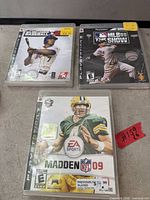 Front view of three PS3 game cases: Madden NFL 09, MLB 09 The Show, Major League Baseball 2K6