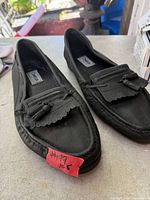 Top view of both shoes showing leather upper, tassels, size tag