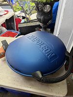 Closed Napoleon TravelQ grill showing blue lid and handles