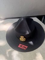Full view of black OPP campaign hat with badge on brim