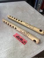 Two bamboo flutes with Haiti inscription on metal surface