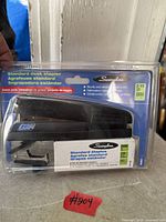 Front view of sealed packaging showing stapler and staple box