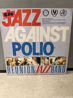 Front cover of Jazz Against Polio vinyl LP showing title graphics and band photo strip