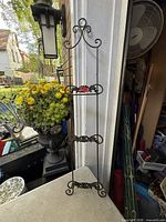 Full view of wrought iron plate rack leaning against doorway