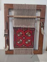 Full view of loom frame with woven sample and tools attached