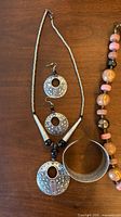 Hammered metal disc pendant necklace, matching earrings, cuff bracelet, partial ceramic bead necklace
