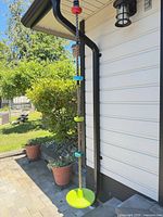 Full view of rope swing hanging from gutter showing seat disc, grip discs and carabiner attachment