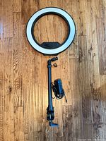 Front view of 18-inch LED ring light with attached adjustable arm and power adapter