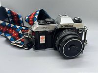 Front left view of Konica FT-1 Motor with Hexanon 50 mm lens and strap