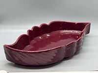 Angled view of burgundy leaf ceramic tray showing side profile and glossy finish