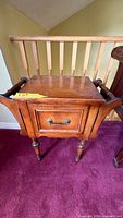 Front view of side table showing drop leaves folded down and cabinet door