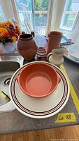 All items grouped: plates, terracotta bowl, jug, vase, pitcher, lidded jar