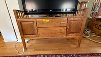 Front view of oak TV stand with drawers and cabinet doors
