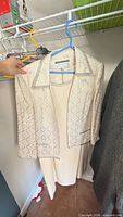 Cream dress and lace jacket on hanger