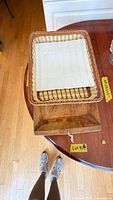 Overview of wicker tray with ceramic plate inside and wooden dough bowl below