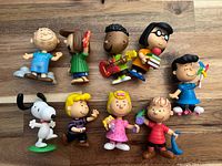 Front view of all nine Peanuts figurines
