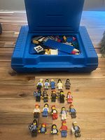 Case open showing loose bricks and parts with minifigures arranged below