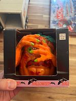 Front of retail box with cutout window showing pumpkin and price label