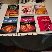 Six chess books arranged in two rows of three on table