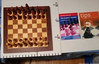 Chess board with pieces and two books