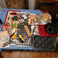 Overview of entire lot on table showing pans, utensils, molds