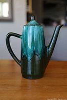 Full view of coffee pot with lid on showing glaze pattern and form