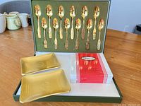 Open presentation case showing 12 spoons, two trays and boxed Pimpernel coasters