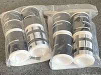 Two plastic packs containing total eight black road-pattern tape rolls