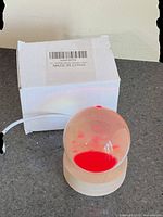 Box with globe light showing red illumination on wood base