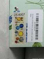 Model code DS-8007 and planet sticker preview on packaging