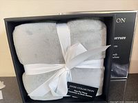Boxed grey faux fur throw with ribbon tie