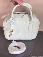 Front and top view of mint woven handbag with handles and separate strap