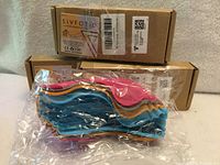 Retail boxes labeled SiVFOTiD and plastic-wrapped stack of multicolour silicone holders