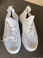 Top view of white mesh sneakers laces tied